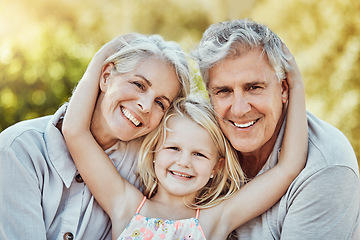 Image showing Grandparents, park and child hug portrait with a young girl and elderly people with love and smile. Care, bonding together and nature of a family feeling happy with kid and elderly grandparent