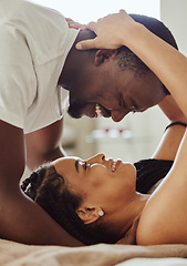 Image showing Black couple, love and home bedroom romance while happy and intimate together on bed at home, apartment or hotel. Face of young man and woman in happy marriage with commitment and care on honeymoon