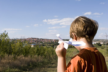 Image showing young boy flying a paper plane