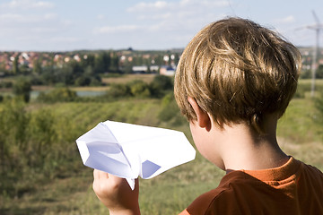 Image showing young boy flying a paper plane