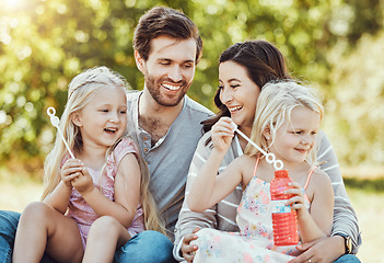 Image showing Family, bubbles and park fun outdoor feeling happiness, love and parent care with children. Happy mom, dad and girl kids in nature on grass relax on vacation on summer holiday together with a smile