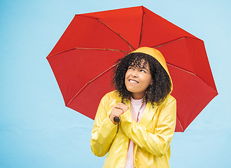 Image showing Young african woman, umbrella and wall with smile, rain and fashion raincoat for safety, wellness or protection. Thinking gen z girl, winter or check sky for weather, walk or urban outdoor adventure