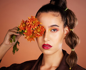 Image showing Makeup, beauty or woman in studio with flowers for art fashion and natural facial cosmetics for self care. Face portrait, orange plants or girl model with red lipstick, eyeshadow and glowing skin