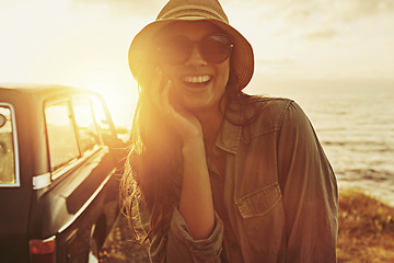 Image showing Portrait, sunset and road trip with a black woman outdoor enjoying travel as a tourist by the sea or ocean in nature. Beach, car and summer with a female tourist taking a scenic drive on the coast