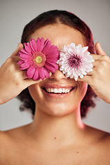 Image showing Woman, face and flower eyes with smile for natural skincare, beauty or cosmetics isolated on a grey background. Happy female, person or lady smiling in happiness holding colorful plant petals for art