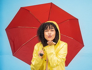 Image showing Woman, portrait or blowing kiss and rain umbrella on isolated blue background in Brazil city love or support. Black person, raincoat or flirty student and facial expression or water weather insurance