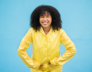 Image showing Black woman, smile and happiness in portrait with rain coat,.fashion for winter and beauty isolated on blue background. Happy in studio, style and jacket with mockup, trendy and excited female