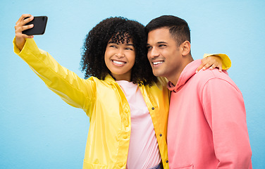 Image showing Happy couple, bonding and phone selfie on isolated blue background for social media, profile picture and travel vlog. Smile, happy man and black woman on mobile photography technology in Brazil city