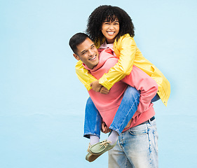 Image showing Happy couple, bonding or piggyback on isolated blue background in city travel, date or fun game. Smile, happy or man carrying black woman in silly, goofy or playful activity in trust, support or love