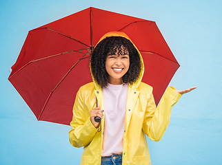 Image showing Black woman, portrait and rain umbrella and hand checking for drops on isolated blue background in Brazil city. Happy person, student and raincoat for weather protection, rainfall water or insurance