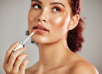 Image showing Woman, lips and lipstick application for beauty, cosmetics dermatology and skincare wellness in grey background. Female model, thinking face and lip gloss brush or makeup product for self care