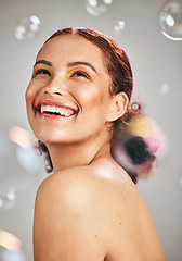 Image showing Happy face, bubbles and woman in studio for skincare cosmetics, natural skin glow and dermatology. Facial makeup, health and wellness of aesthetic model person with luxury body product and hope