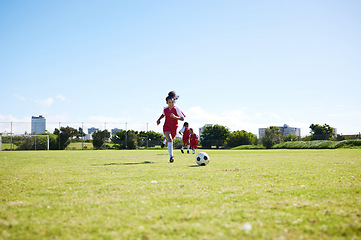 Image showing Soccer, training or children and a girl team playing with a ball together on a field for practice. Fitness, football and grass with kids running or dribblinf on a pitch for competition or exercise