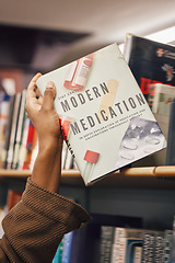 Image showing Book in hand, library and student of medicine, pills and healthcare education and learning about pharmaceutical drugs. Black woman with reading information, learn and study, research for medical test