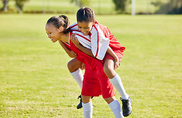 Image showing Girl soccer player, happy celebration and grass with piggyback for goal, teamwork and winning contest. Young female kids, winner and celebrate with support, solidarity and happiness at soccer field