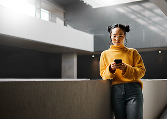 Image showing Woman, phone and texting in office building, relax and calm while on internet, search and reading. Asian, girl and business entrepreneur with smartphone for research, office space or idea in Japan