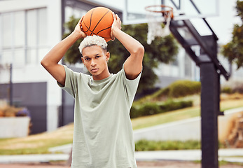 Image showing Basketball, young man and basketball player with sport in park with portrait in city and exercise outdoor. Fitness, athlete on basketball court, focus and urban with sports motivation and training.