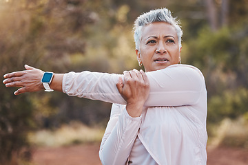 Image showing Exercise, stretching and senior woman outdoor in nature for running, cardio fitness and a workout with a smartwatch. Elderly female in a forest for cardio training for a healthy lifestyle and body