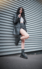 Image showing Young woman smoking, fashion and streetwear with gen z punk style, outdoor and trendy, edgy in urban city. Youth, focus and beauty with rock aesthetic, fashion model in designer clothes in London