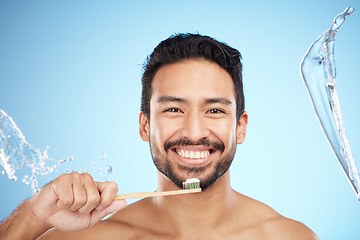 Image showing Face, portrait or man brushing teeth in studio with toothbrush for white teeth or dental healthcare. Water splash, bamboo wood or happy person cleaning or washing mouth with a healthy natural smile