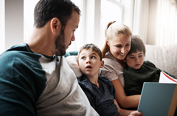 Image showing Man, woman and kids on sofa with book learning to read at storytelling time in living room of home. Love, family and couple with children, books and child development on couch in apartment together.