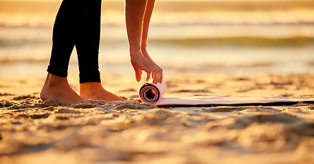 Image showing Beach, hands and woman roll yoga mat getting ready for workout, exercise or stretching. Zen, meditation and feet of female yogi outdoors on seashore while start chakra training and pilates.