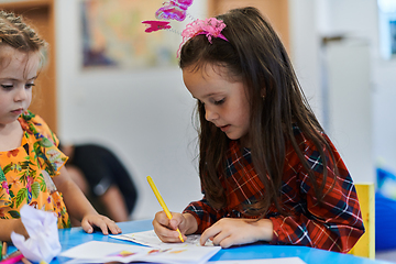 Image showing Creative kids sitting in a preschool institution, draw and have fun while they get an education