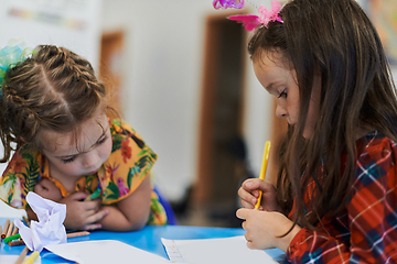 Image showing Creative kids sitting in a preschool institution, draw and have fun while they get an education