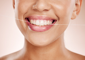 Image showing Floss, woman and smile with dental care, clean mouth and after brushing teeth against studio background. Oral health, Latino female and girl with string, fresh breath and morning routine for hygiene