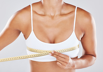 Image showing Breast, measure tape and woman isolated on white background for cosmetics, plastic surgery and lose weight. Liposuction, health and wellness of person or model with boobs for beauty results zoom