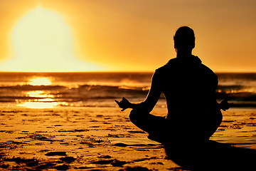 Image showing Lotus, yoga and silhouette of man at beach outdoors for health and wellness. Sunset, zen meditation and shadow or outline of male yogi meditating, chakra training and mindfulness exercise at seashore