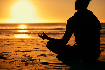 Image showing Meditation, lotus and silhouette of man at beach outdoors for health and wellness. Sunset, zen yoga and shadow or outline of male yogi meditating, chakra training and mindfulness exercise at seashore