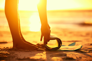 Image showing Hands, beach and woman roll yoga mat getting ready for workout, exercise or stretching at sunset. Zen, meditation and feet of female yogi outdoors on seashore while preparing for training and pilates