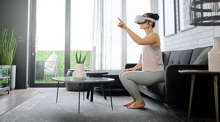 Image showing VR, metaverse and gaming with a woman in the living room of her home using a headset to access a 3d game. Futuristic, virtual reality and technology with a female gamer using ai to play games