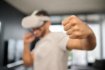 Image showing VR, action and fist of a man boxing on a game, training for fight and match. Futuristic, digital sports and gamer punching while playing in an augmented reality with technology glasses in a house