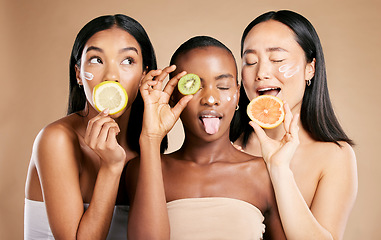 Image showing Diversity, women and fruit for natural beauty, dermatology and healthy lifestyle with girls on brown studio background. Cosmetics, friends or ladies with vitamin c, skincare and confidence or luxury