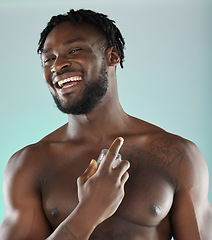 Image showing Portrait, cologne and blue background with a model black man posing shirtless in studio for body spray. Perfume, product or skin with a handsome, muscular and young male standing topless on space