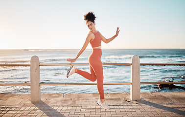 Image showing Fitness, happy running and woman jumping on beach path on fun morning exercise with freedom and happiness. Run, jump and smile, excited girl on healthy ocean walk with joy, wellness and workout goals