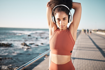 Image showing Fitness music, ocean and woman portrait stretching for exercise warm up, running start or outdoor workout. Beach mockup, health and training African girl, athlete or runner listening to radio podcast