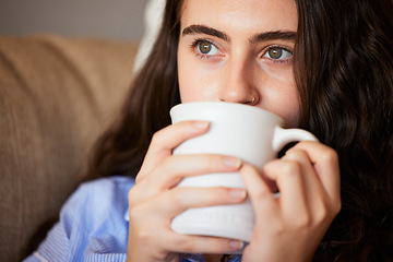 Image showing Relax, calm and woman drinking coffee in the living room on a sofa in her modern house in Australia. Weekend, thinking and lady enjoying a cup of a warm caffeine or tea beverage in her lounge.