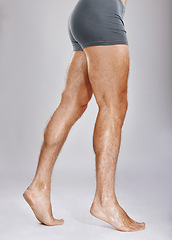 Image showing Man, legs or muscles on studio background for fitness check, workout training goals or studio exercise wellness. Underwear model, bodybuilder and strong athlete feet on gray backdrop for healthcare