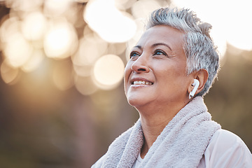 Image showing Fitness, exercise and senior woman listening to music in nature with earphones for running , thinking and wellness. Face of an elderly female outdoor to run for a healthy lifestyle, body and energy