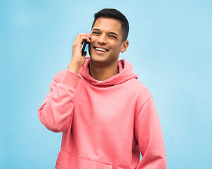 Image showing Casual man, phone call and smile for communication standing isolated on a blue background. Happy male, person or guys with pink jacket in discussion, conversation or talking on mobile smartphone