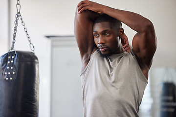 Image showing Black man stretching, boxing gym and training for fitness, wellness or focus for strong body. Man, punching bag and warm up muscle with vision, goal or development in workout, mma exercise or health