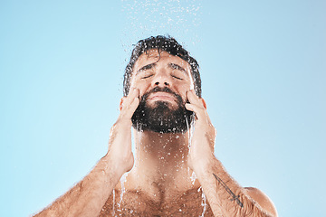 Image showing Man, shower and face cleaning for skincare hygiene, body care wellness and grooming health in blue background studio. Water splash, facial spa dermatology and cosmetics beauty or washing in morning