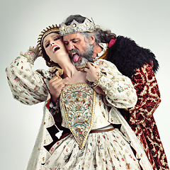 Image showing King, queen and love of couple in studio isolated on a gray background. Vintage royalty, retro victorian and affection, romance and passion of royal man and woman with crown kissing, embrace and hug.