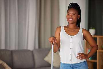 Image showing Black woman, broom and cleaning with a smile and mockup in a home living room. Clean house, happy person and relax cleaner proud of housekeeping work feeling calm with happiness by a lounge sofa