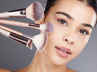 Image showing Makeup, portrait or woman brushes her face with facial cosmetics or luxury skincare products. Glow, aesthetic or beautiful girl model grooming in self care routine isolated on studio background