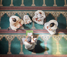 Image showing Above mosque carpet, group and quran for faith, religion and prayer for gratitude, peace or mindfulness. Imam, praying and spiritual development with book, focus and islamic worship on floor in Qatar