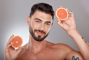 Image showing Face portrait, skincare and man with grapefruit in studio isolated on a gray background. Wellness, nutrition and male model with fruit for healthy diet, facial care and vitamin c, minerals and beauty